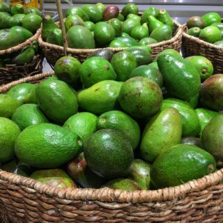 green fruits on brown woven basket
