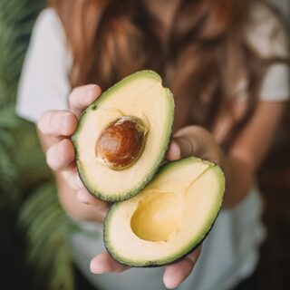 sliced avocado fruit on persons hand