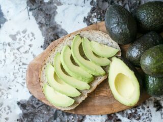 sliced avocado fruit on brown wooden chopping board